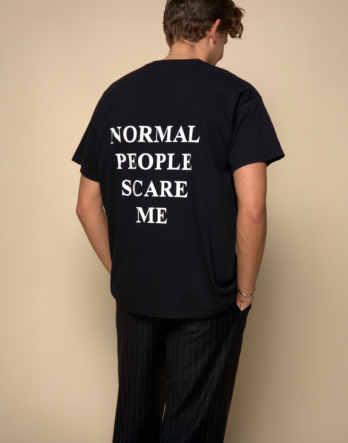 normal people scare me t-shirt black. By FRASED. Unisex heavy cotton tee with a crew neckline and graphic screen print, made from 100% cotton, featuring a classic fit and tear-away label for comfort.