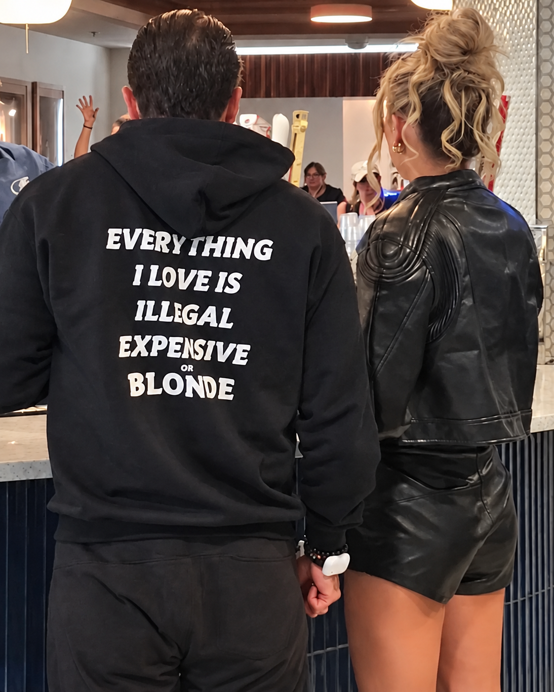 Editorial reproduction of a man in a FRASED Blonde hoodie beside a woman in Tampa