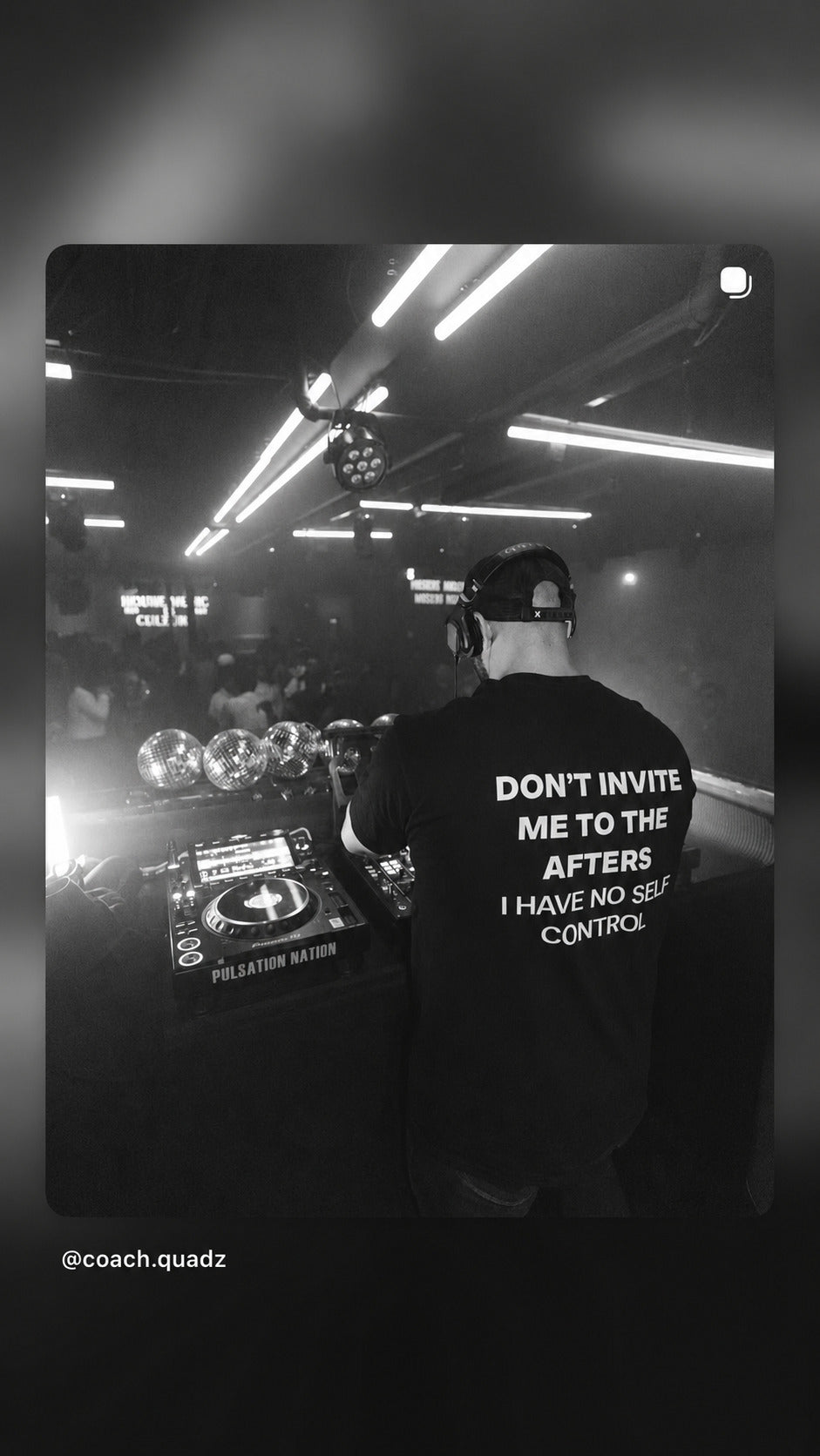DJ ved pulten i sort FRASED T-shirt med 'Don't invite me to the afters. I have no self control' på ryggen; sort-hvidt klubfoto.