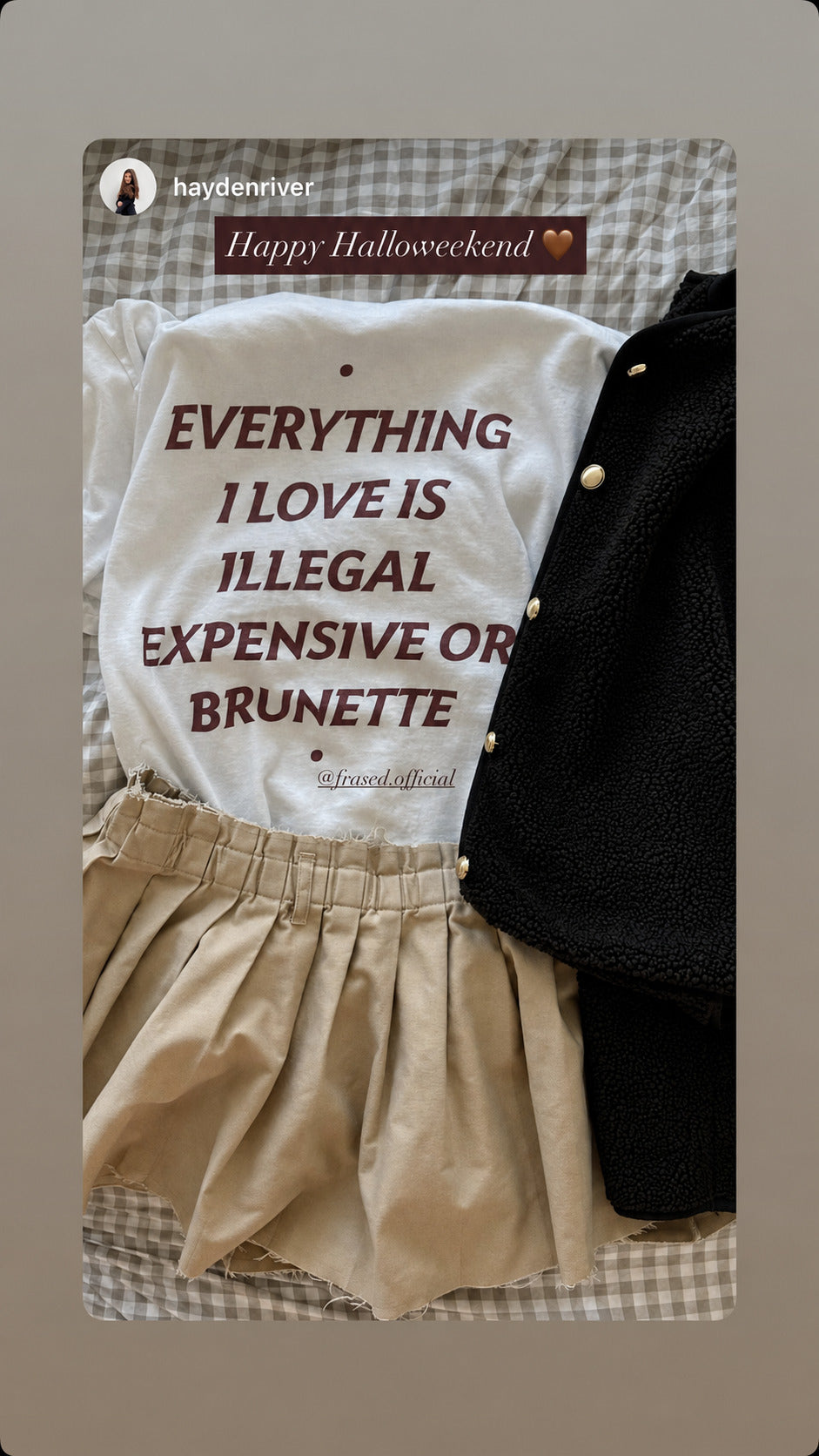 Hvid EVERYTHING I LOVE IS ILLEGAL, EXPENSIVE OR BRUNETTE T-shirt lagt frem med beige nederdel og sort jakke.