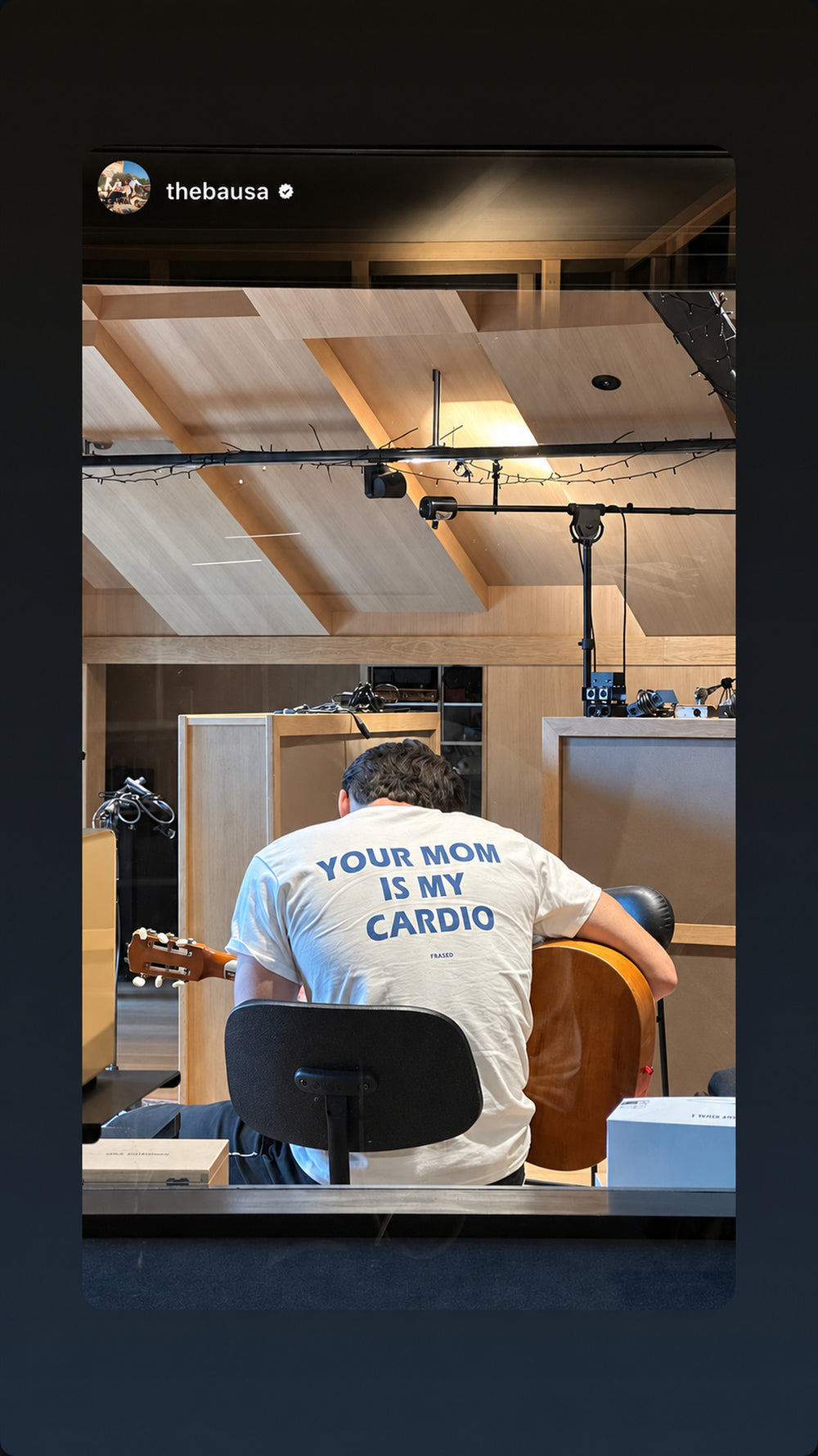 Person med guitar i studie iført hvid FRASED T-shirt med 'Your Mom Is My Cardio' på ryggen.