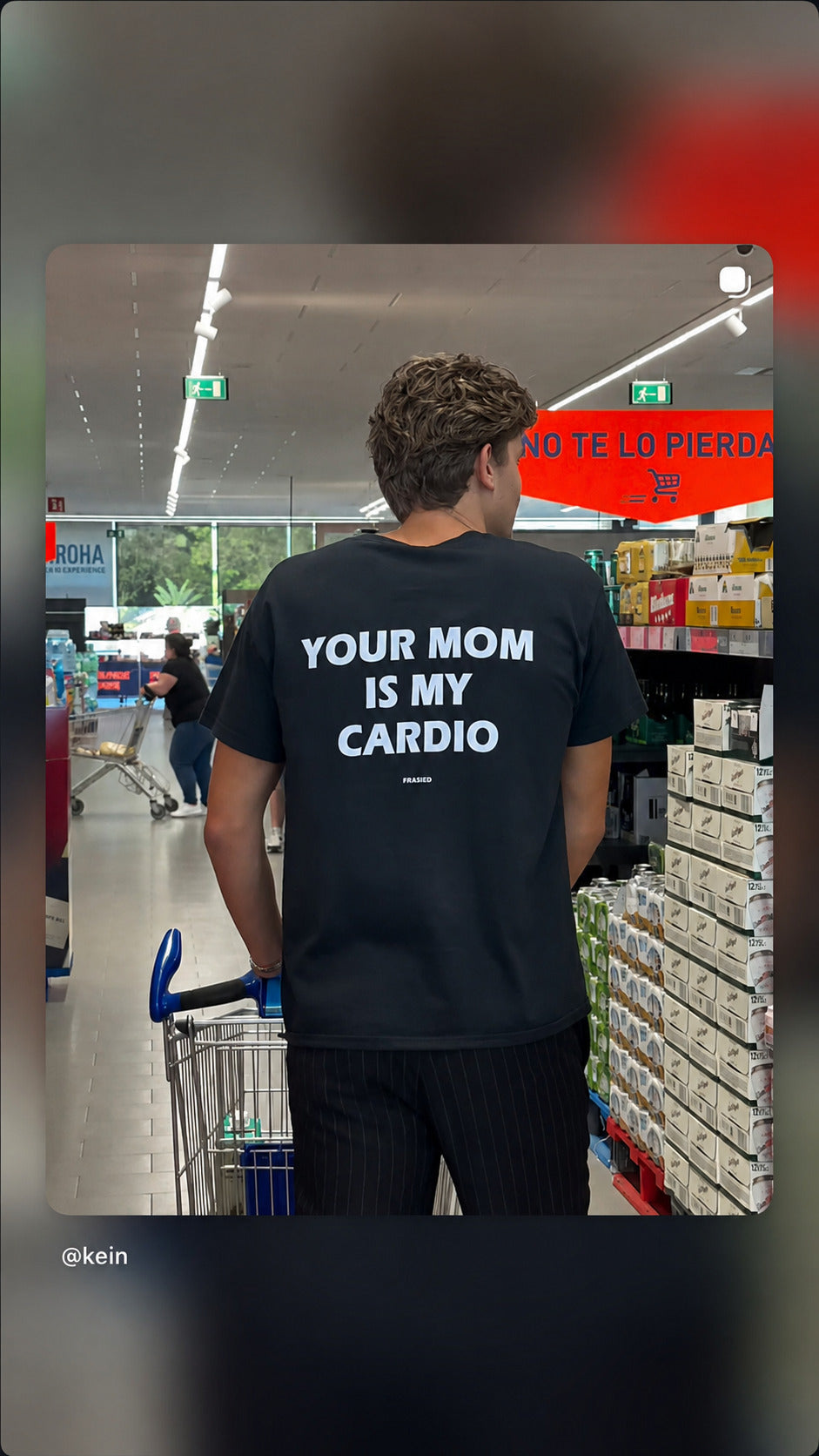 Mand med indkøbsvogn i sort FRASED T-shirt med 'Your Mom Is My Cardio' på ryggen.