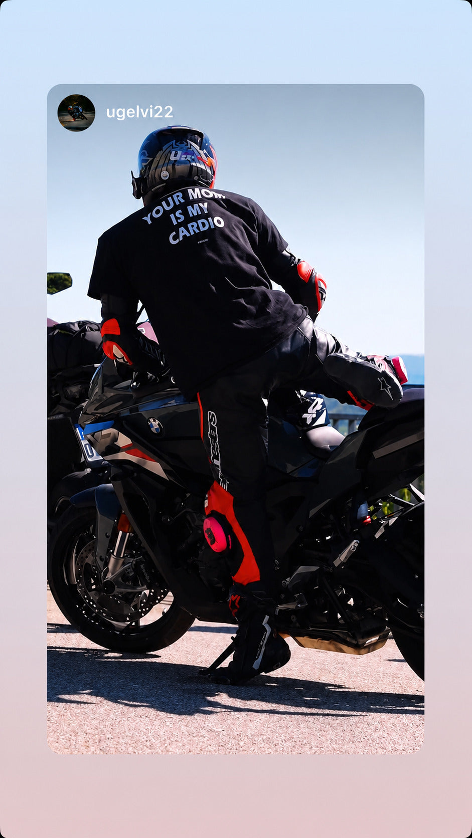 Motorcyklist ved sin motorcykel i sort FRASED T-shirt med 'Your Mom Is My Cardio' på ryggen.