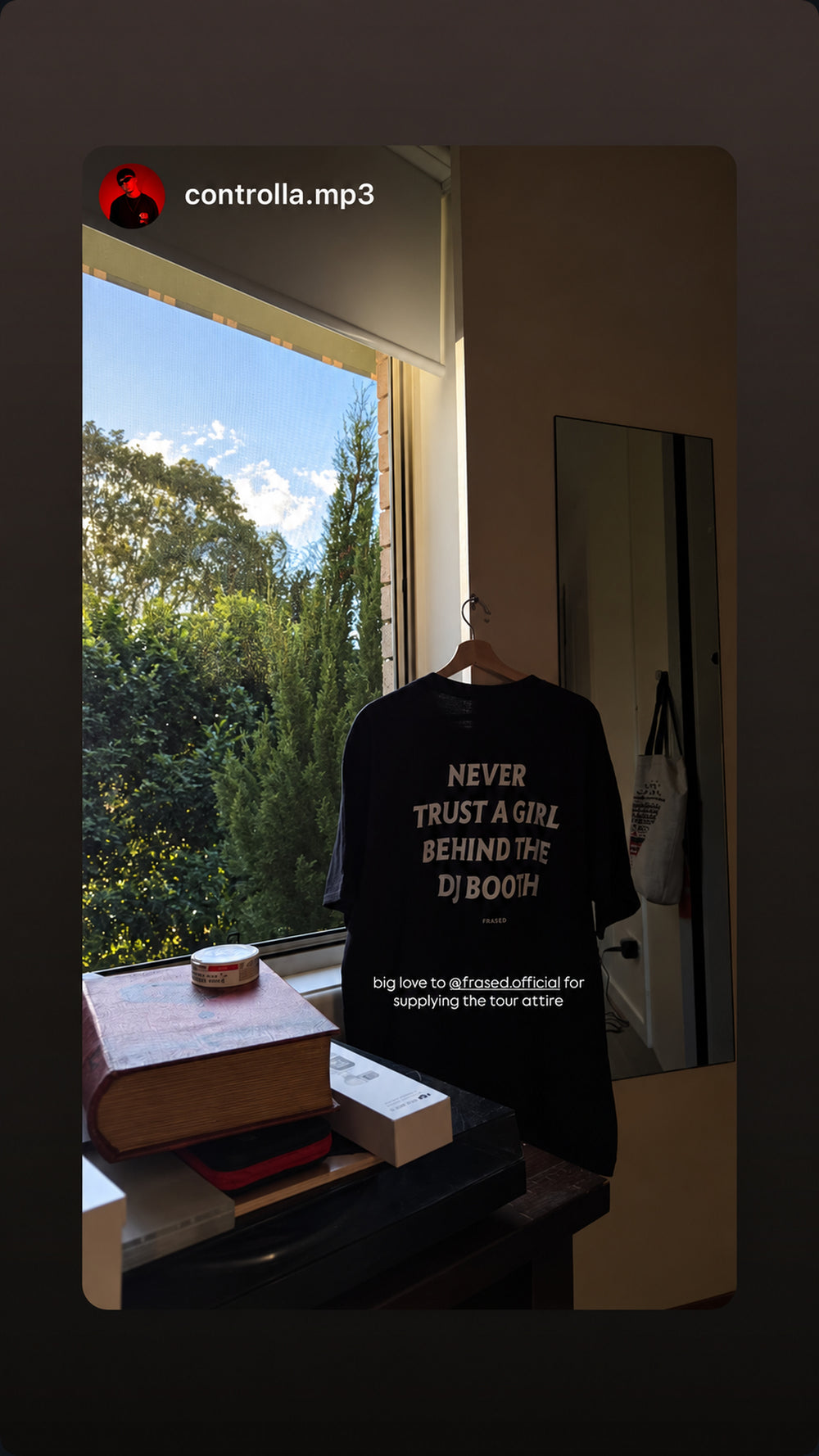 Sort NEVER TRUST A GIRL BEHIND THE DJ BOOTH T-shirt hænger ved vindue
