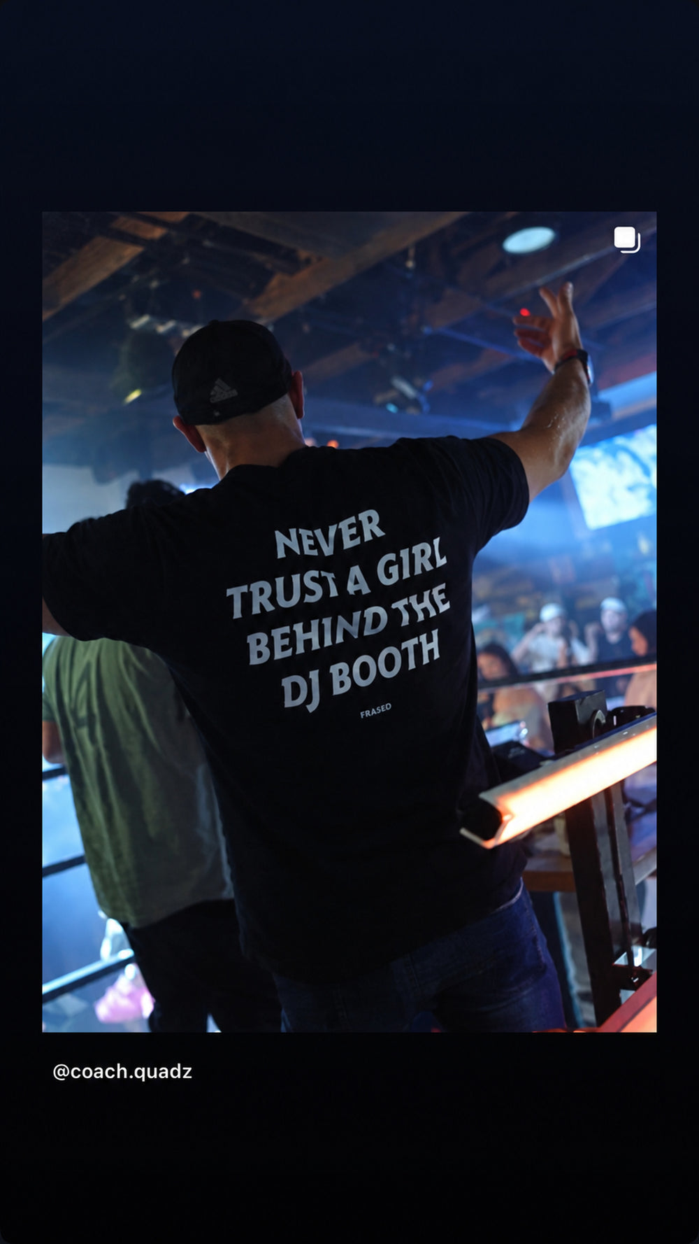 Mand i sort NEVER TRUST A GIRL BEHIND THE DJ BOOTH T-shirt ved DJ-pult