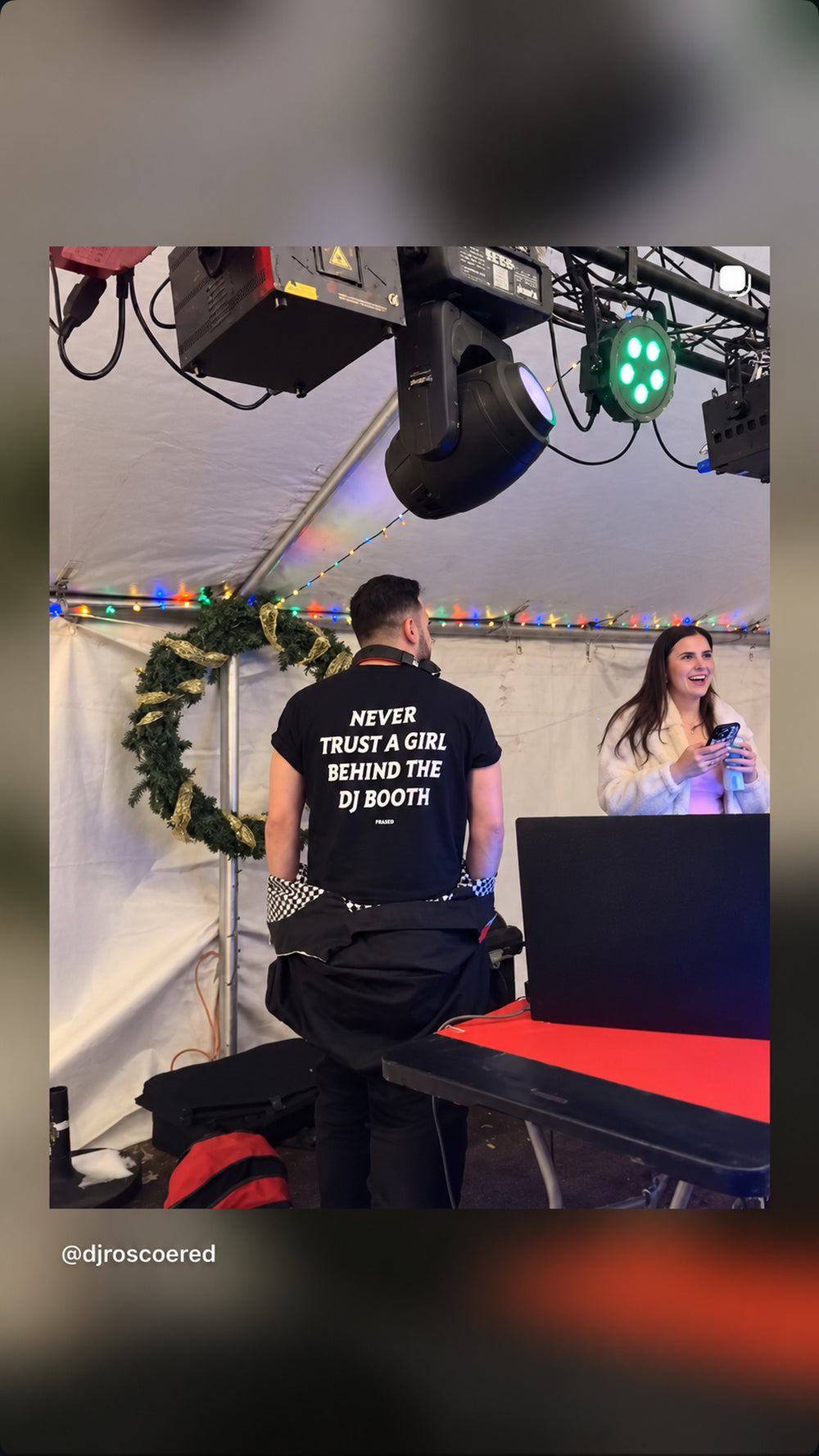 DJ i sort NEVER TRUST A GIRL BEHIND THE DJ BOOTH T-shirt ved laptop i telt