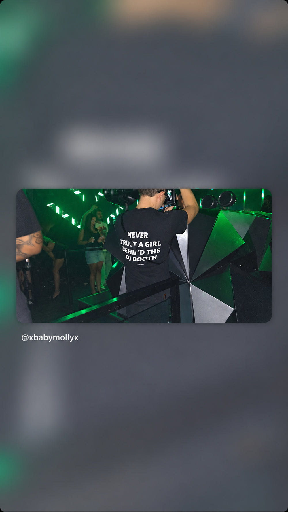 Person i sort NEVER TRUST A GIRL BEHIND THE DJ BOOTH T-shirt i grønt klublys