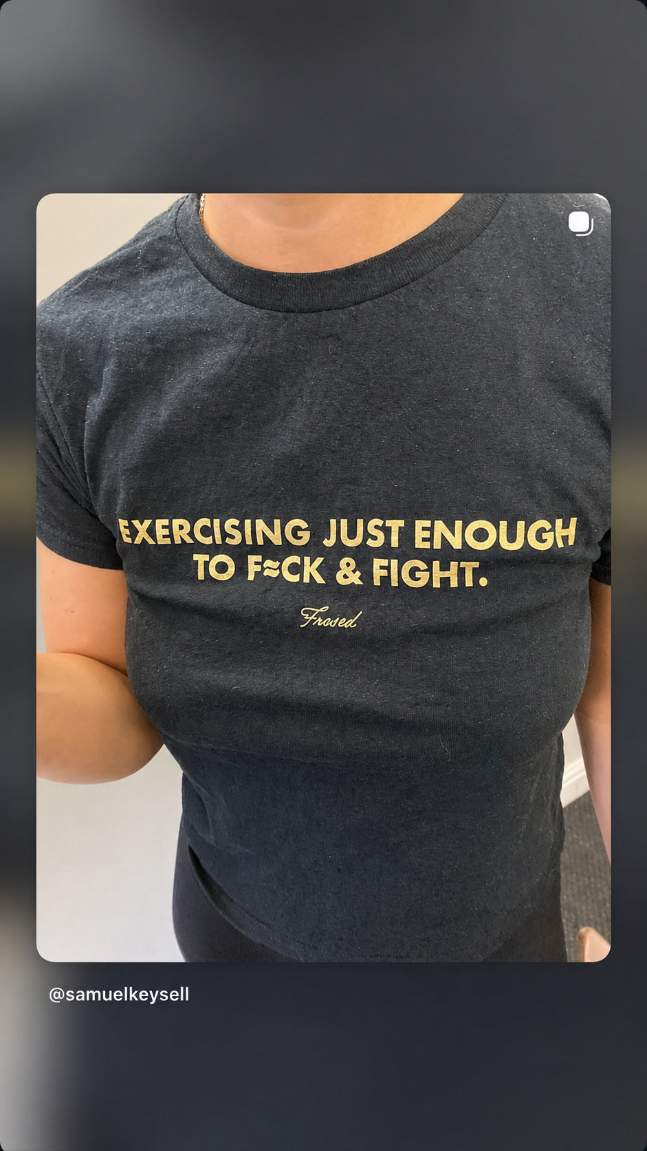 Nærbillede af beige print på sort EXERCISING JUST ENOUGH TO F*CK & FIGHT baby tee