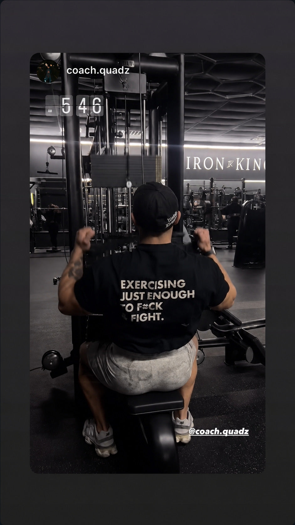 Man training on a gym machine in a black “EXERCISING JUST ENOUGH TO F*CK & FIGHT” T-shirt.