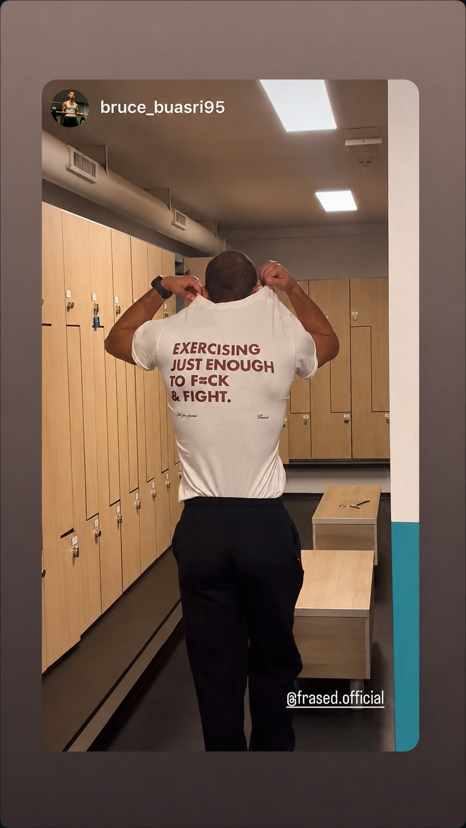 Man in a locker room wearing a white “EXERCISING JUST ENOUGH TO F*CK & FIGHT” T-shirt.