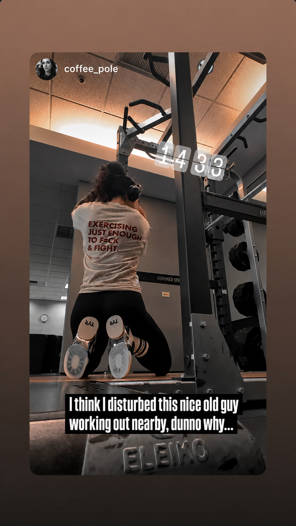 Person working out at a gym in a white “EXERCISING JUST ENOUGH TO F*CK & FIGHT” T-shirt.
