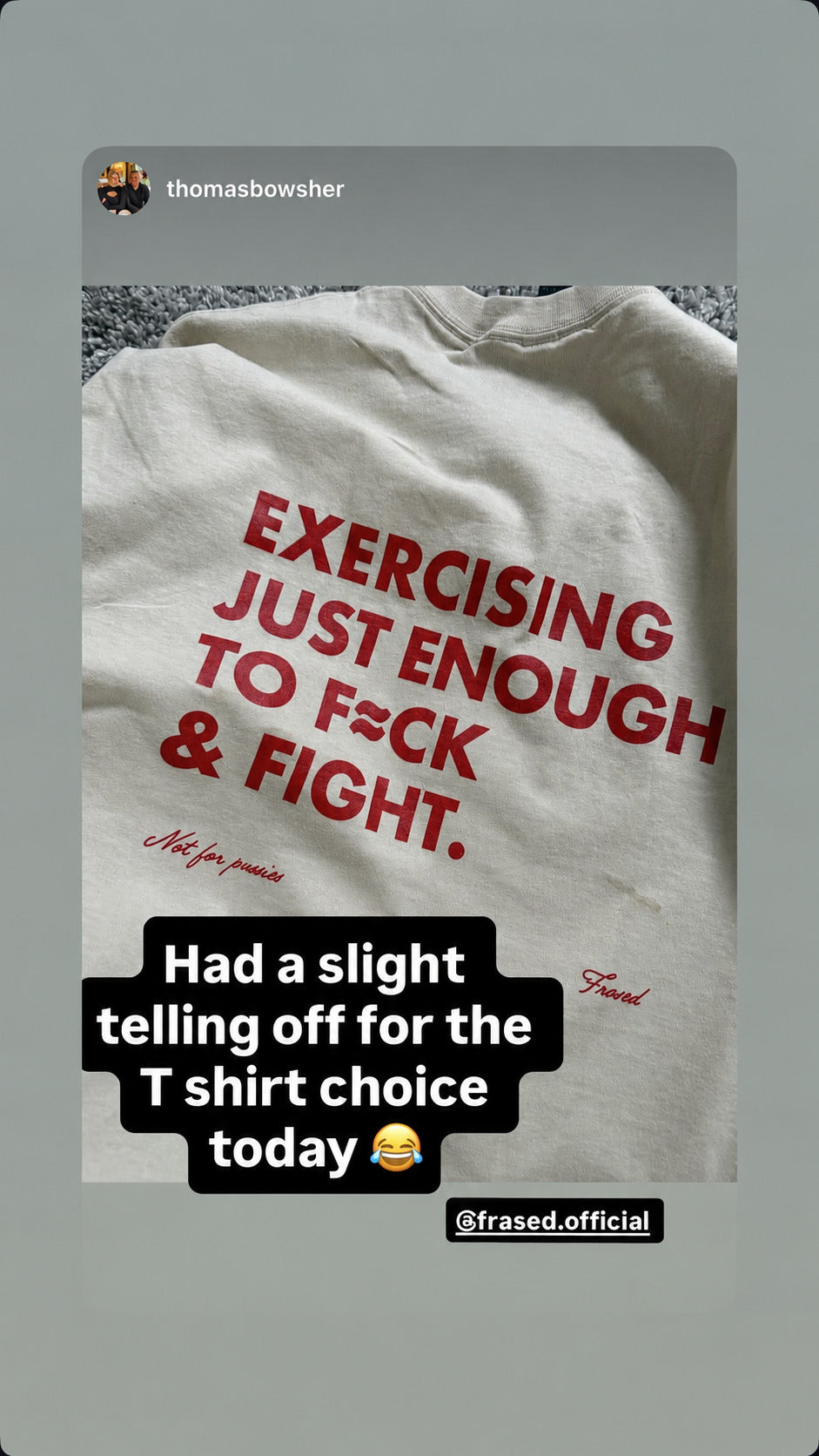 Close-up of red “EXERCISING JUST ENOUGH TO F*CK & FIGHT” lettering on a white T-shirt.