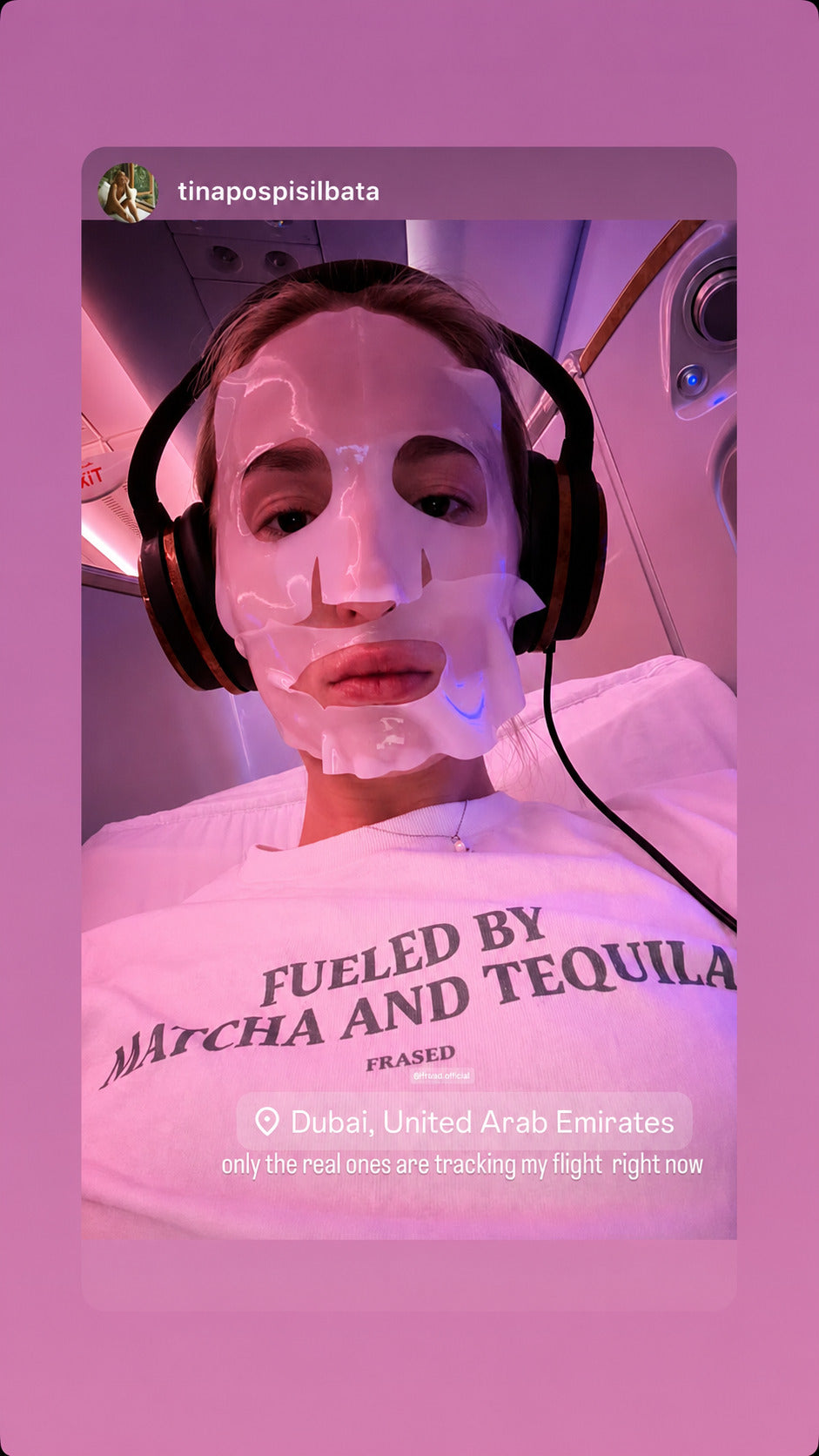 Selfie i fly af person med hovedtelefoner og ansigtsmaske iført hvid FRASED T-shirt med 'Fueled by Matcha and Tequila' på brystet.