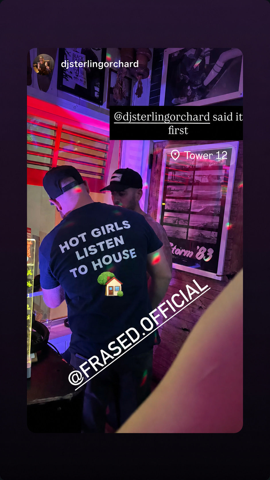 Man seen from behind at a colorful bar in a black “HOT GIRLS LISTEN TO HOUSE” T-shirt.