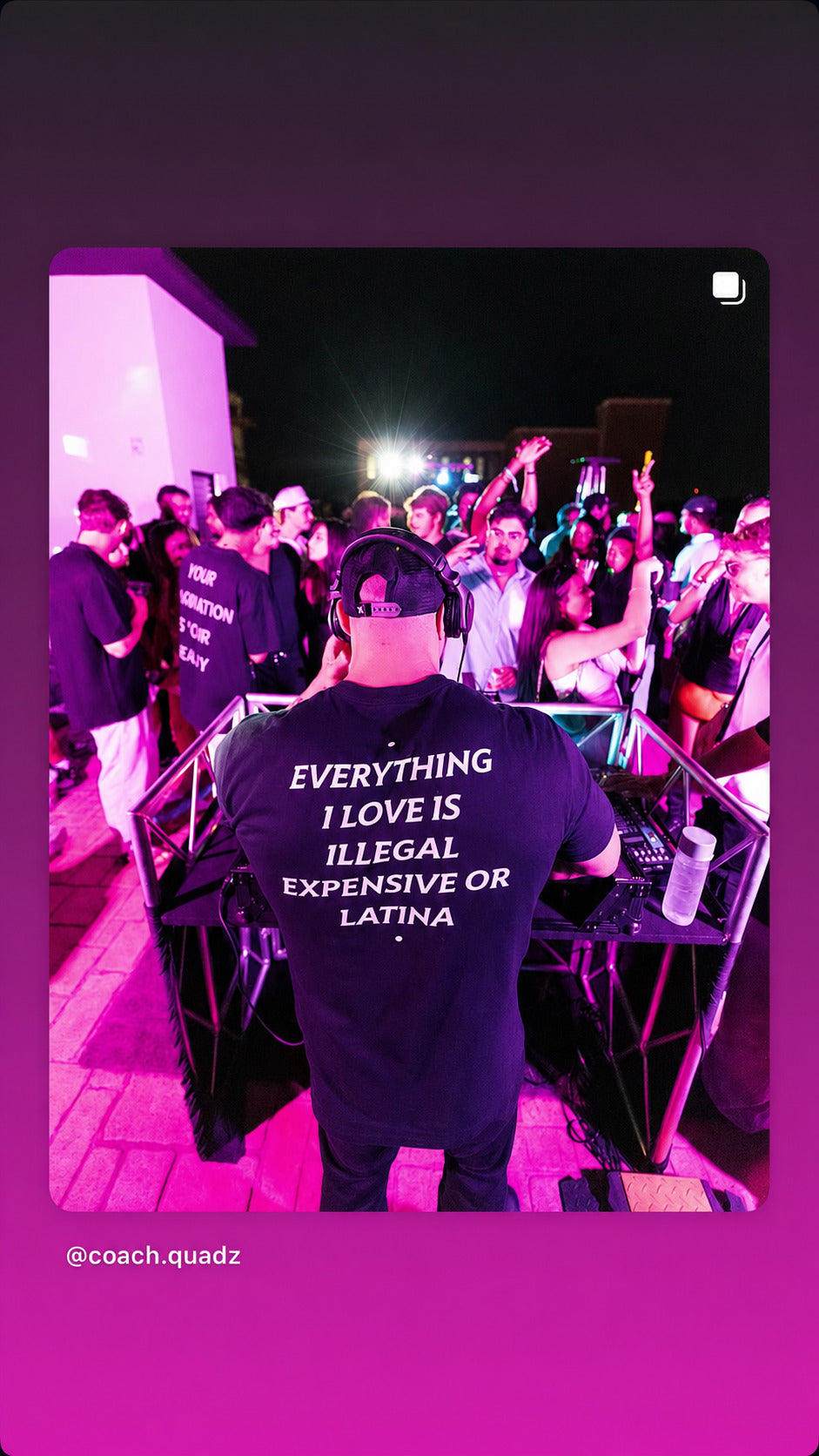 DJ i sort EVERYTHING I LOVE IS ILLEGAL, EXPENSIVE OR LATINA T-shirt spiller for et publikum i lilla lys.