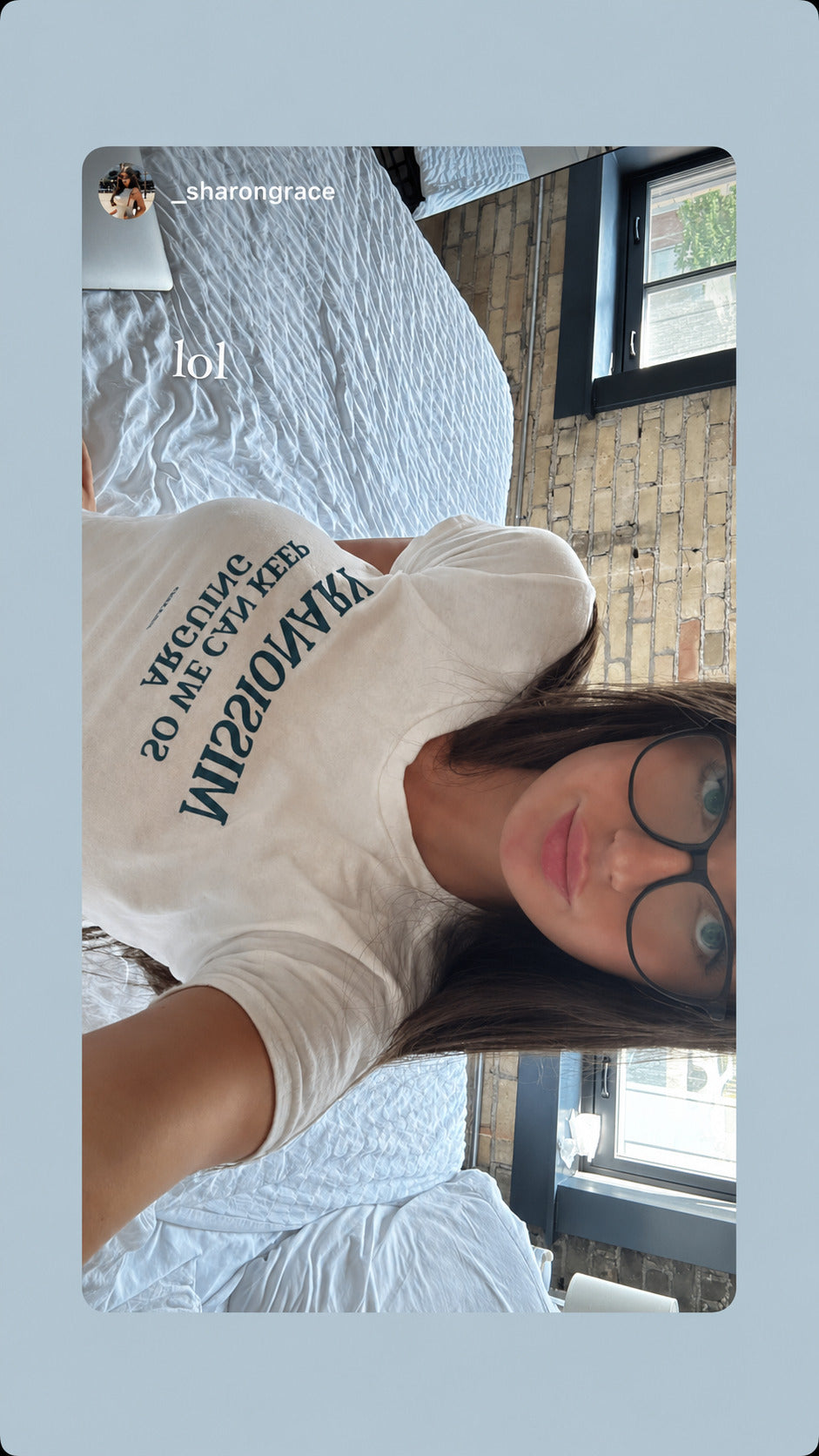 Selfie of a woman in glasses wearing a white FRASED baby tee with “Missionary So We Can Keep Arguing” on the chest.