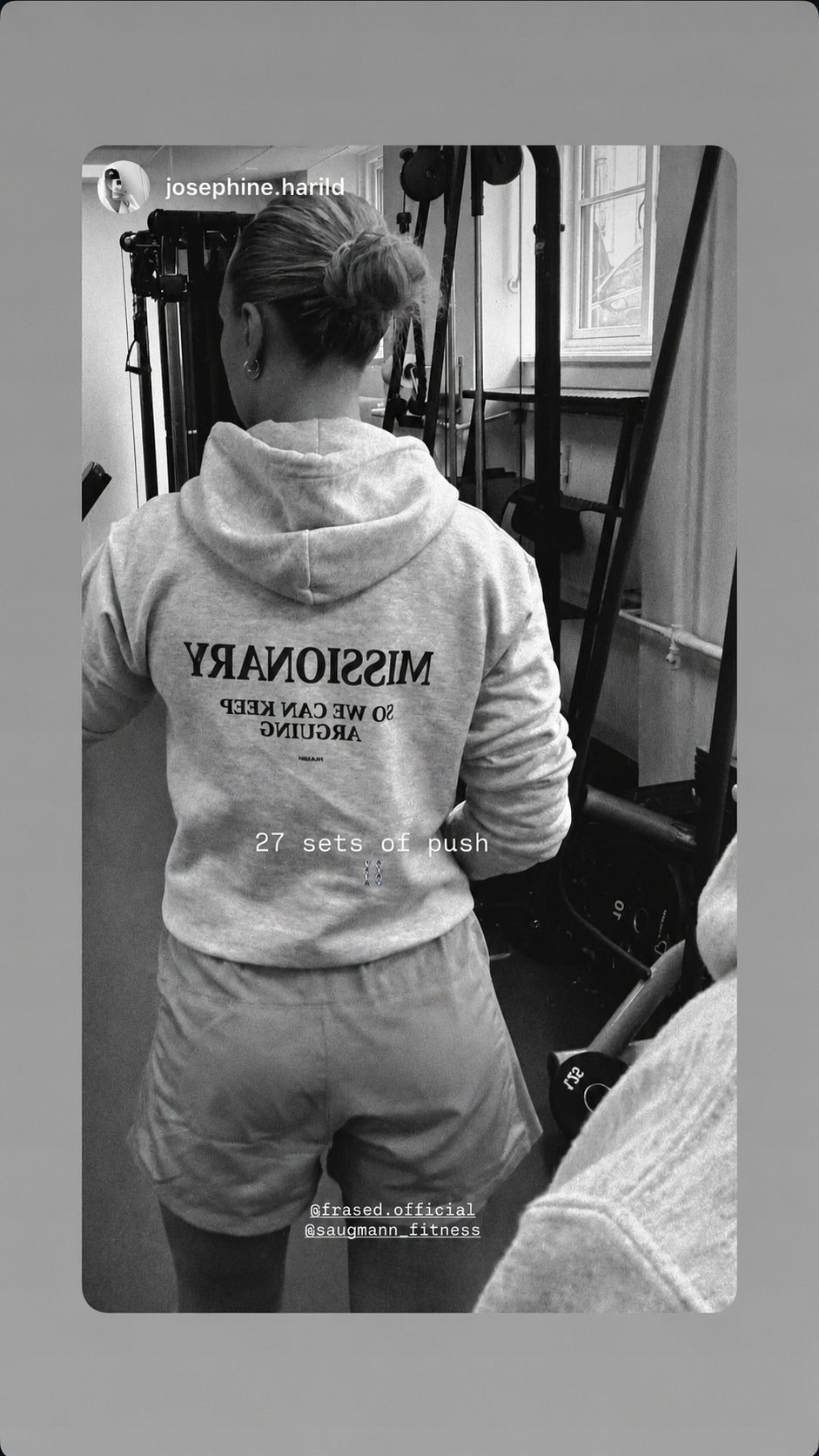 Black-and-white gym mirror selfie of a woman in a gray FRASED hoodie with “Missionary So We Can Keep Arguing” on the back.