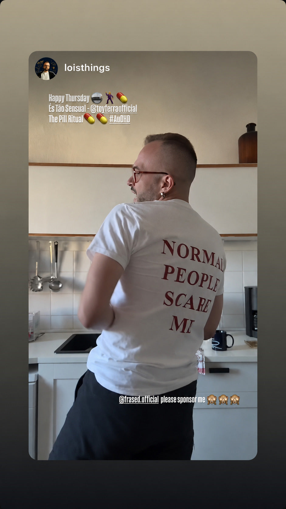 Mand i hvid NORMAL PEOPLE SCARE ME T-shirt set bagfra i et køkken.