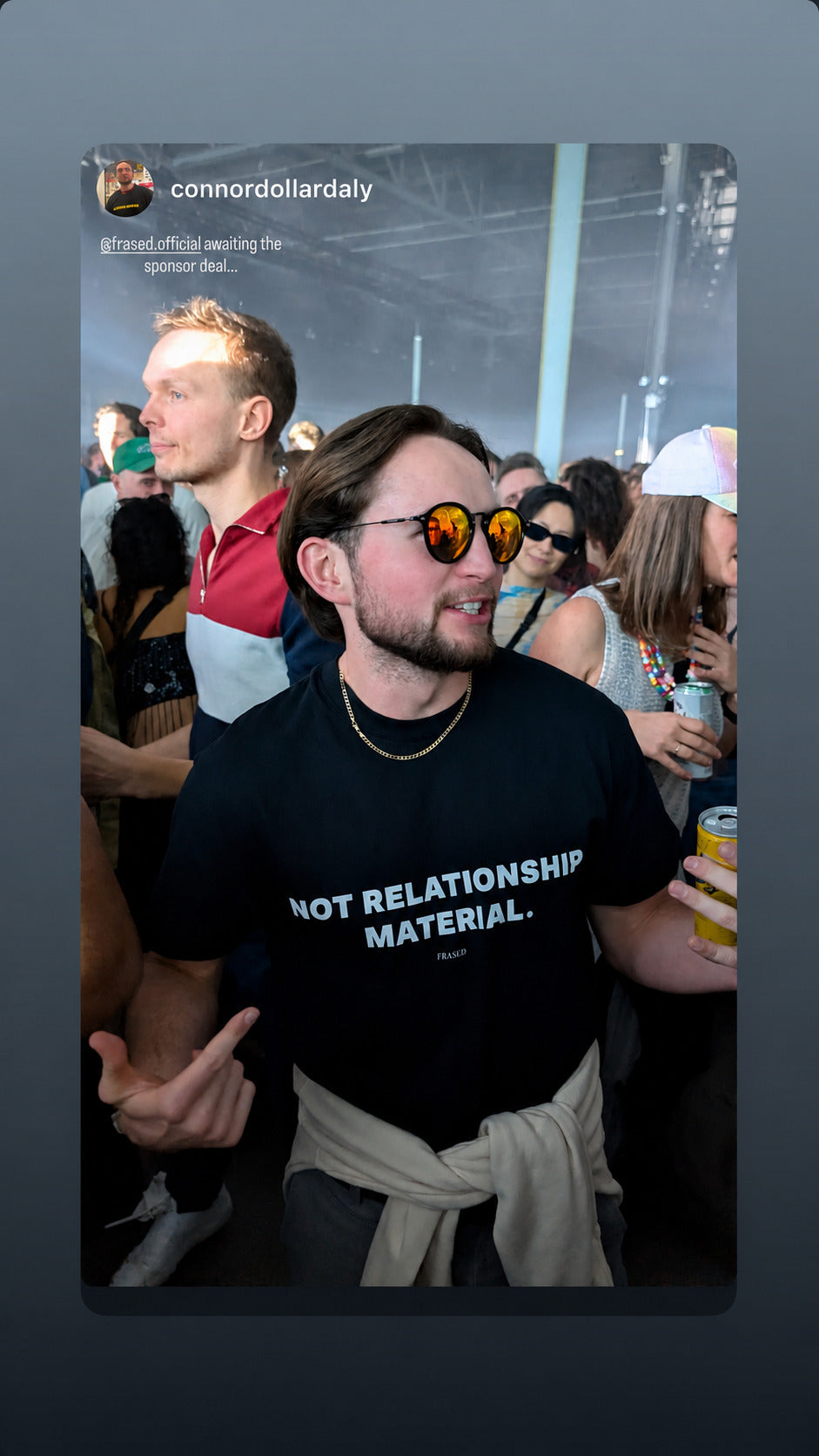 Man at a party in a black FRASED T-shirt with “Not Relationship Material” printed on the chest.