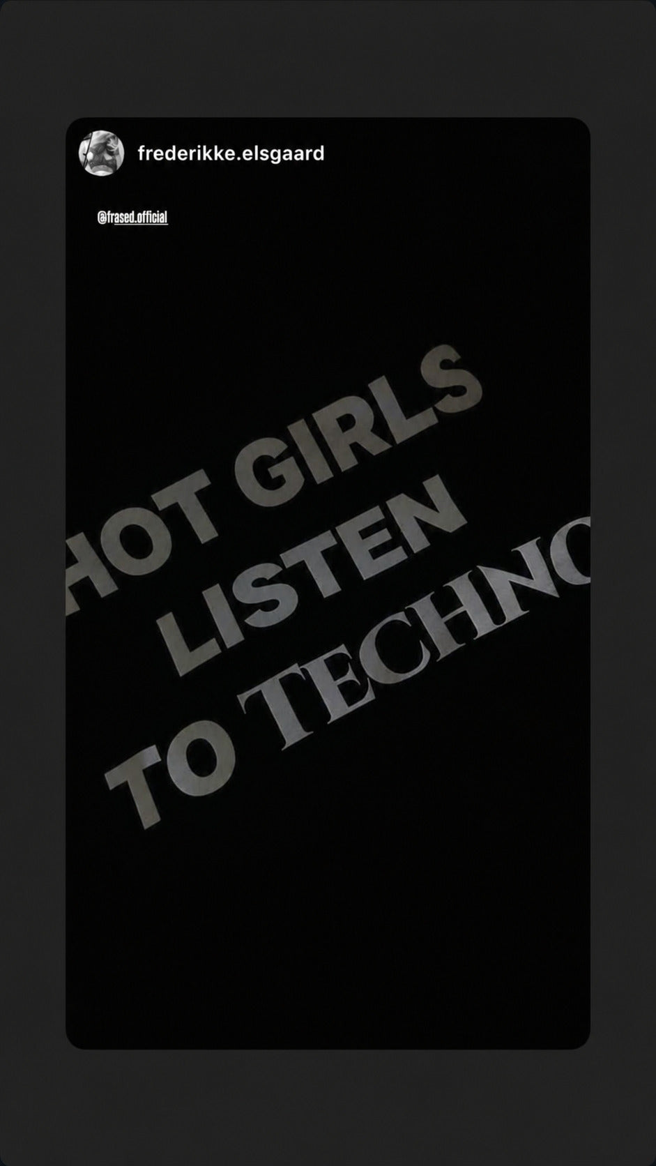 Close-up of a black “HOT GIRLS LISTEN TO TECHNO” T-shirt with large white lettering.