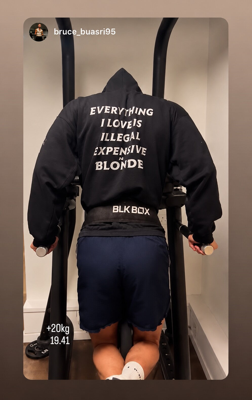 Person doing dips in a black hoodie with “EVERYTHING I LOVE IS ILLEGAL EXPENSIVE OR BLONDE” on the back.