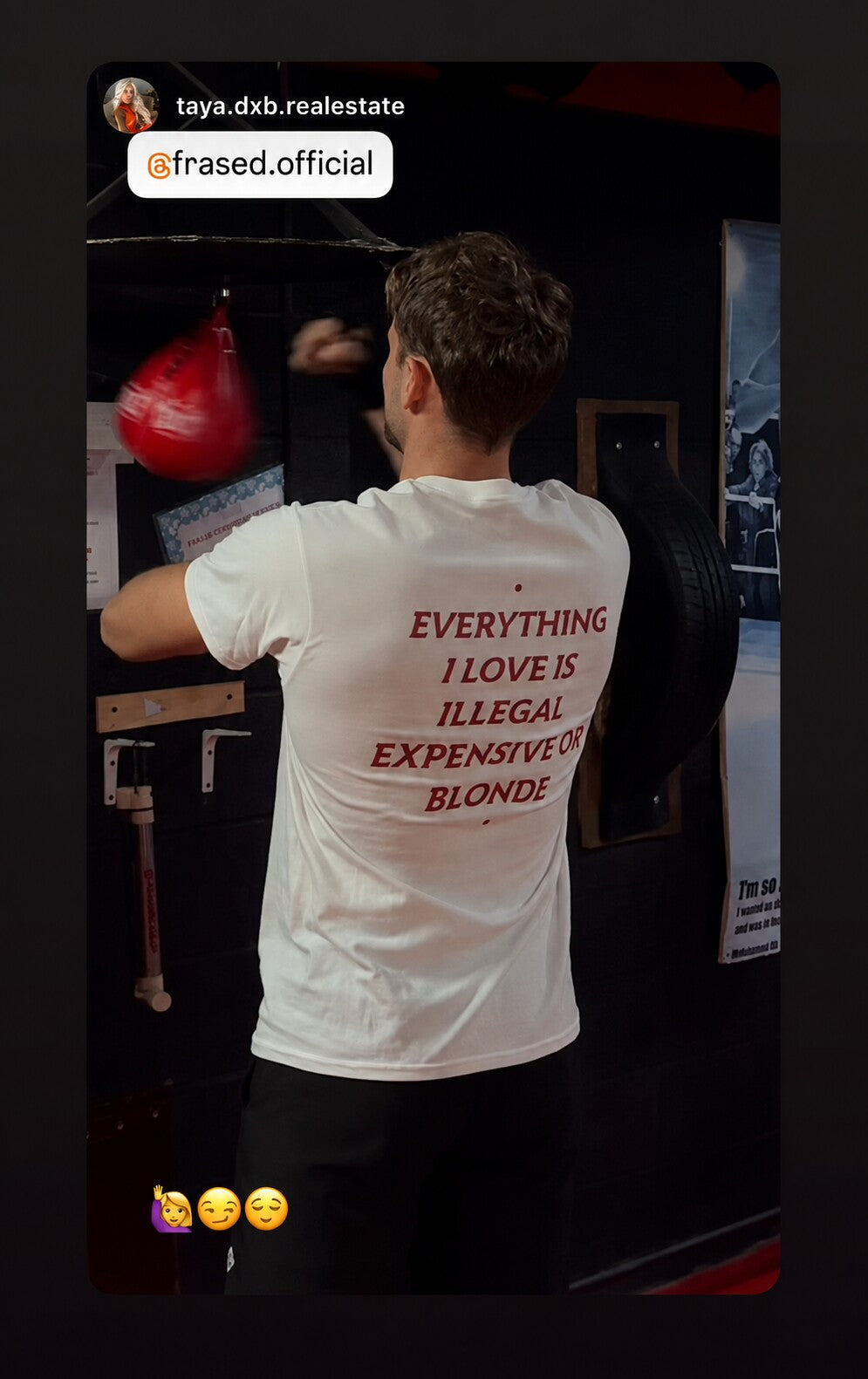 Man beside a punching bag in a white “EVERYTHING I LOVE IS ILLEGAL EXPENSIVE OR BLONDE” T-shirt.
