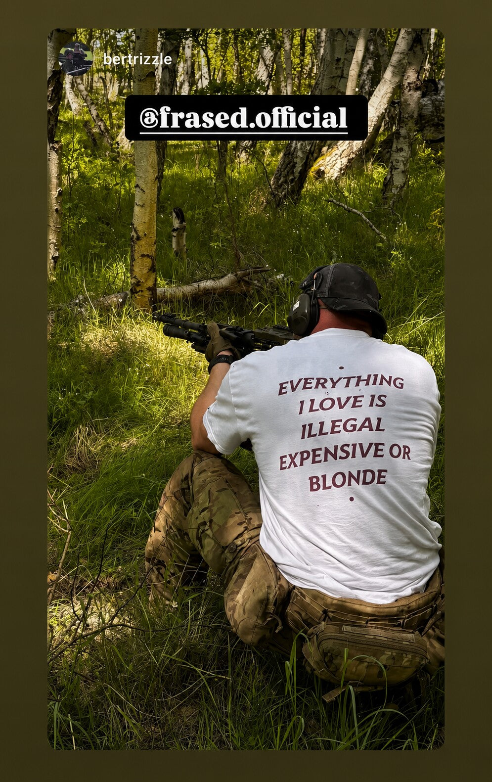 Person kneeling in a forest wearing a white “EVERYTHING I LOVE IS ILLEGAL EXPENSIVE OR BLONDE” T-shirt.