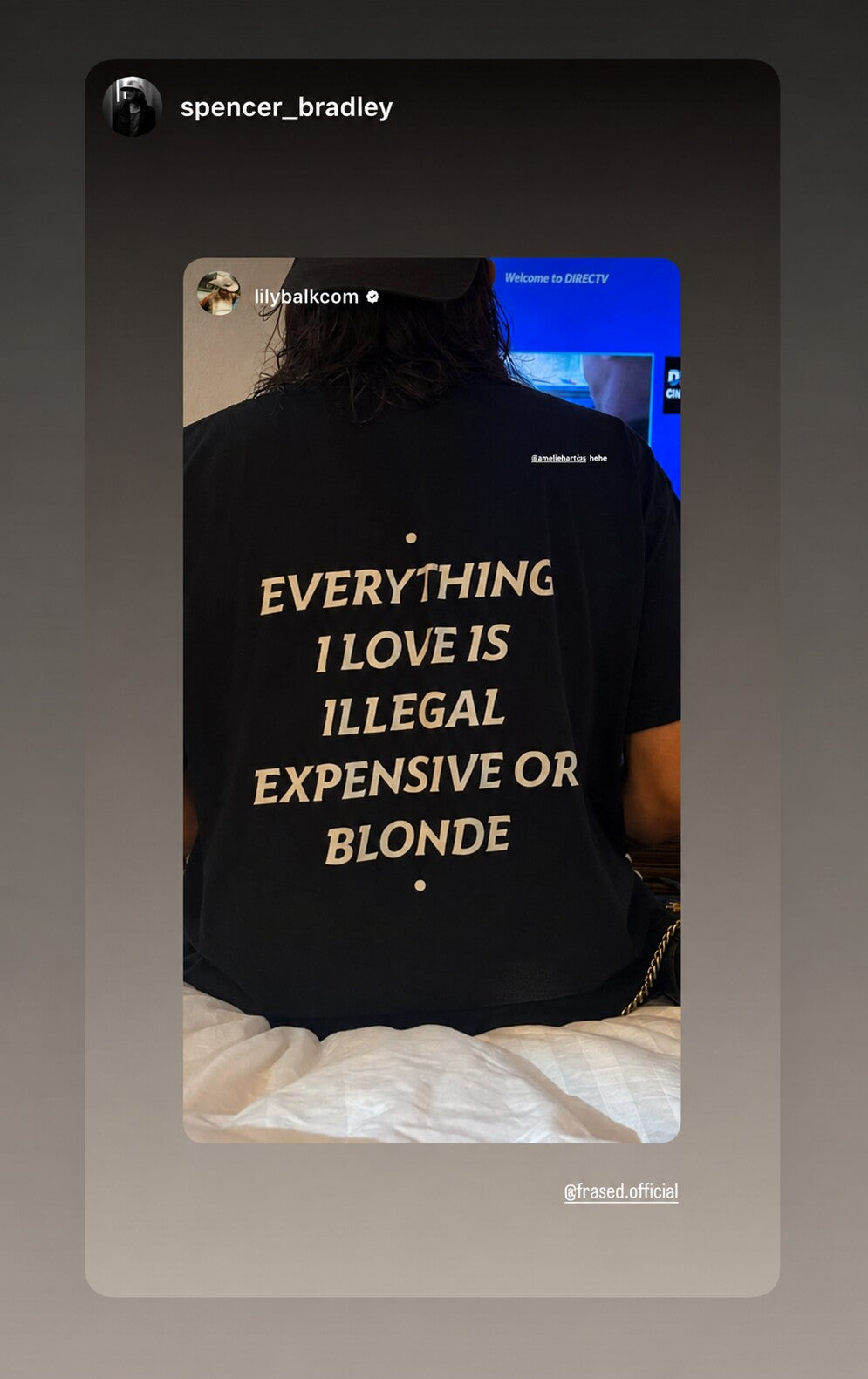 Person sitting on a bed in a black “EVERYTHING I LOVE IS ILLEGAL EXPENSIVE OR BLONDE” T-shirt.