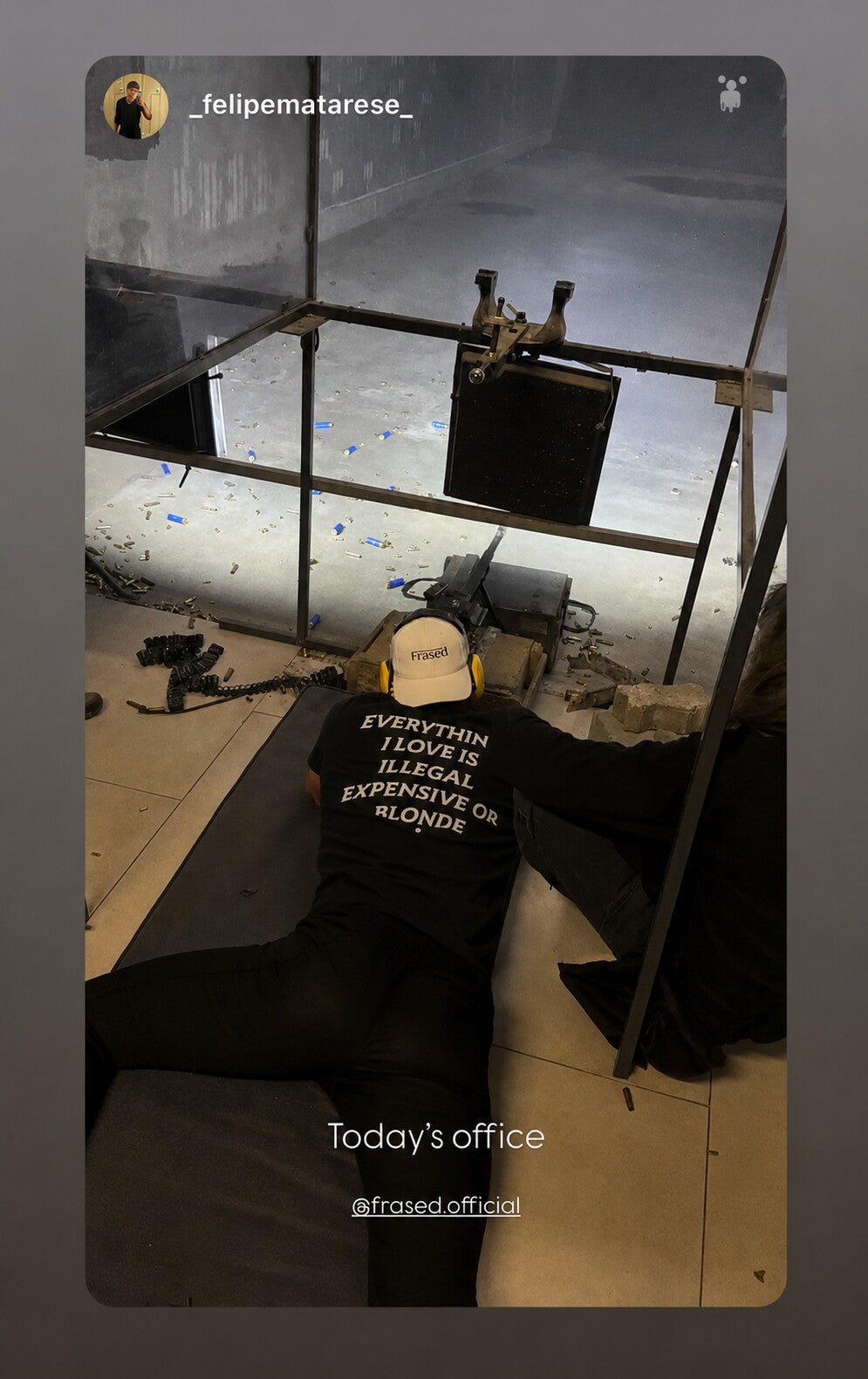 Person sitting on the floor by a workstation in a black “EVERYTHING I LOVE IS ILLEGAL EXPENSIVE OR BLONDE” T-shirt.