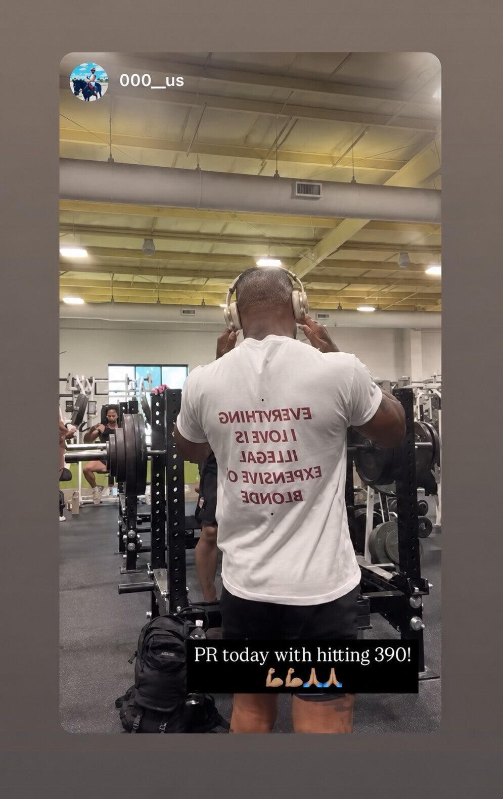 Man at a gym wearing a white “EVERYTHING I LOVE IS ILLEGAL EXPENSIVE OR BLONDE” T-shirt.