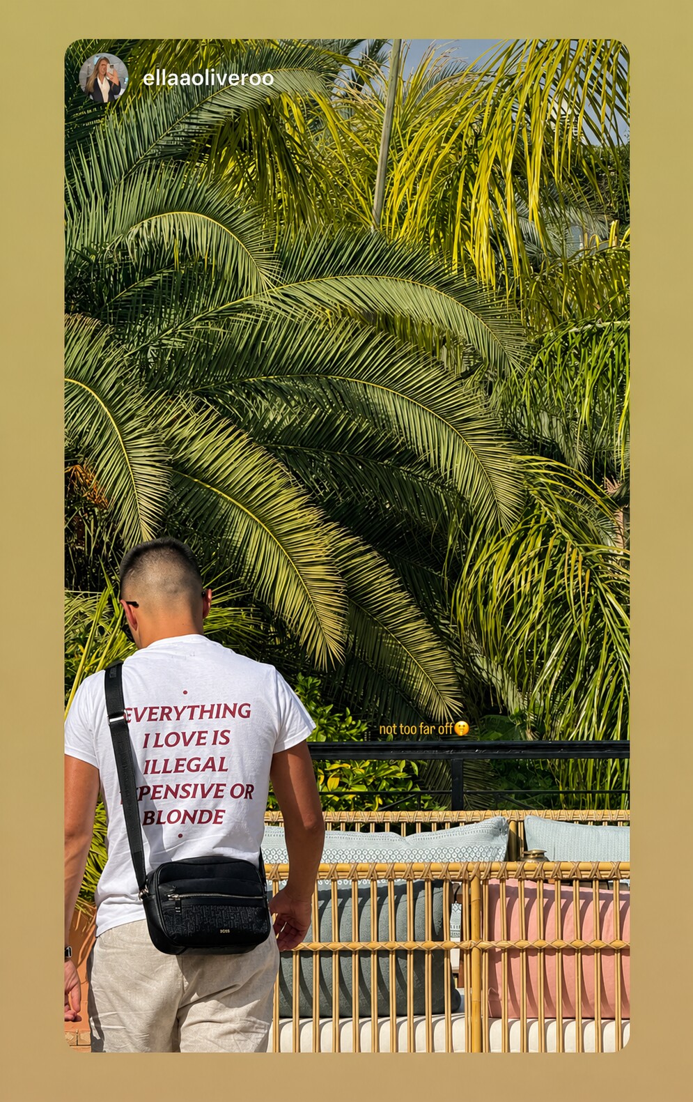 Man beside palm trees in a white “EVERYTHING I LOVE IS ILLEGAL EXPENSIVE OR BLONDE” T-shirt.