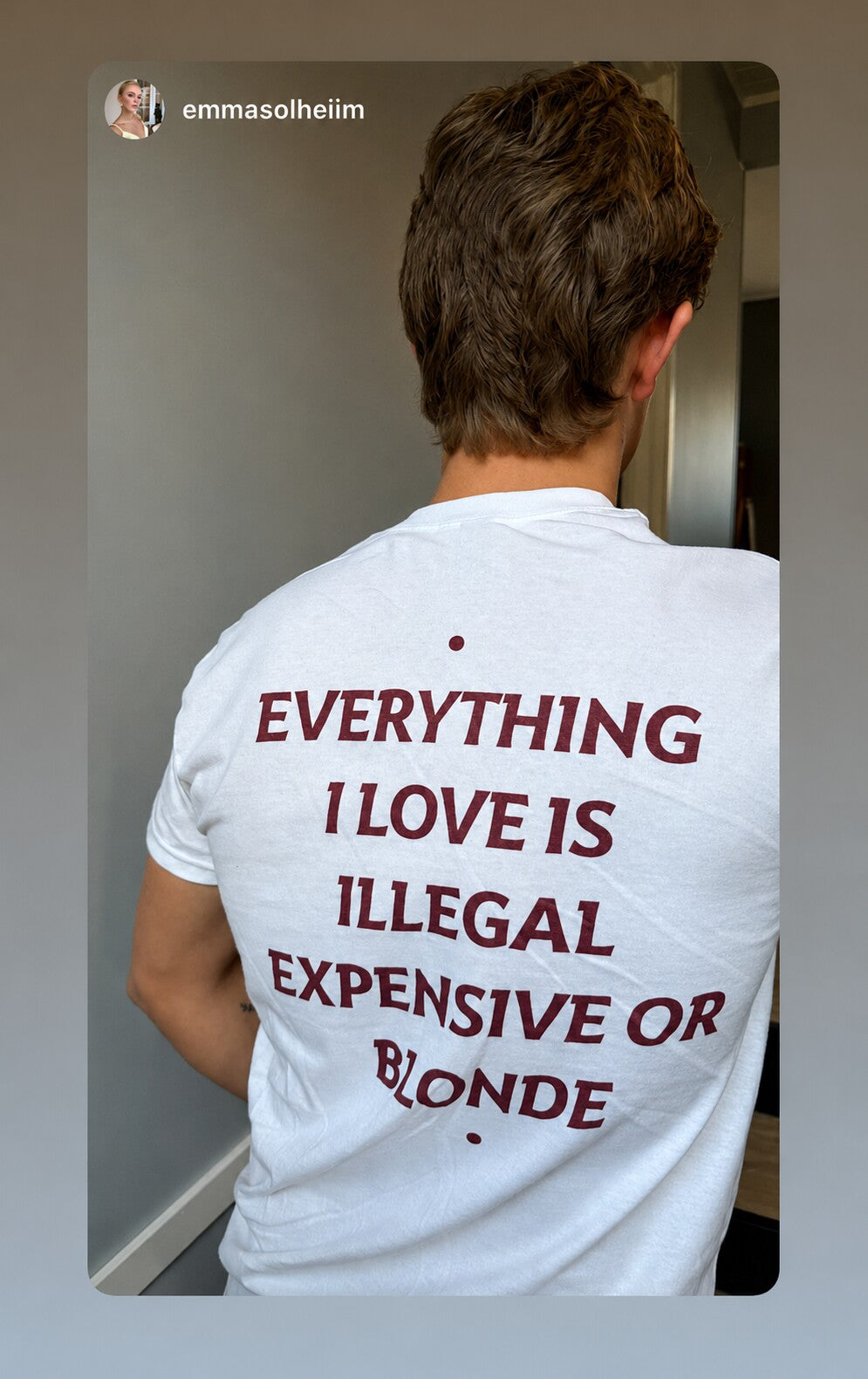 Close-up of the back print on a white “EVERYTHING I LOVE IS ILLEGAL EXPENSIVE OR BLONDE” T-shirt.